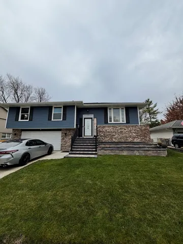 a front view of a house with a garden and trees