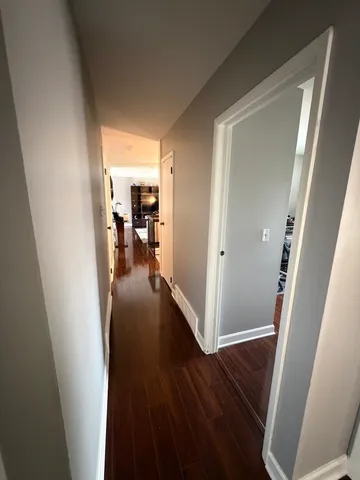 a view of a hallway and a livingroom with furniture
