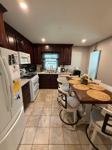 a kitchen with stainless steel appliances granite countertop a sink dishwasher a refrigerator and cabinets with wooden floor