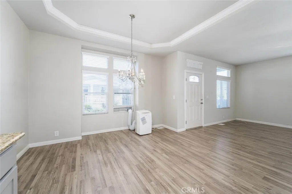 16222 Monterey Lane, Unit 285 Huntington Beach, CA 92649 - Photo 17 of 59 a view of an empty room with window and wooden floor