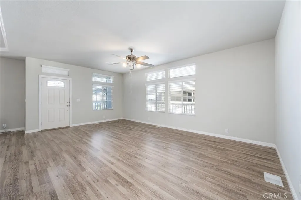 16222 Monterey Lane, Unit 285 Huntington Beach, CA 92649 - Photo 18 of 59 a view of an empty room with a window and wooden floor