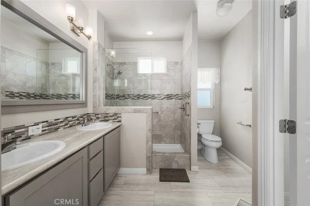 16222 Monterey Lane, Unit 285 Huntington Beach, CA 92649 - Photo 21 of 59 a bathroom with a sink toilet a mirror and a shower