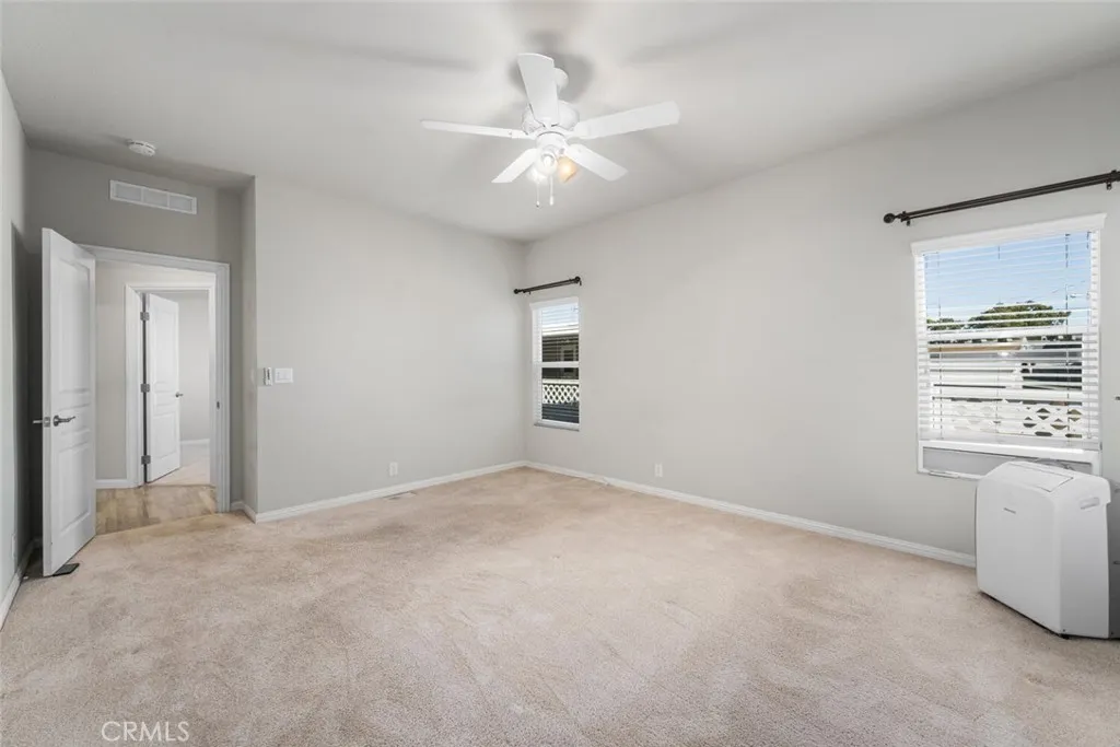 16222 Monterey Lane, Unit 285 Huntington Beach, CA 92649 - Photo 23 of 59 an empty room with windows and ceiling fan