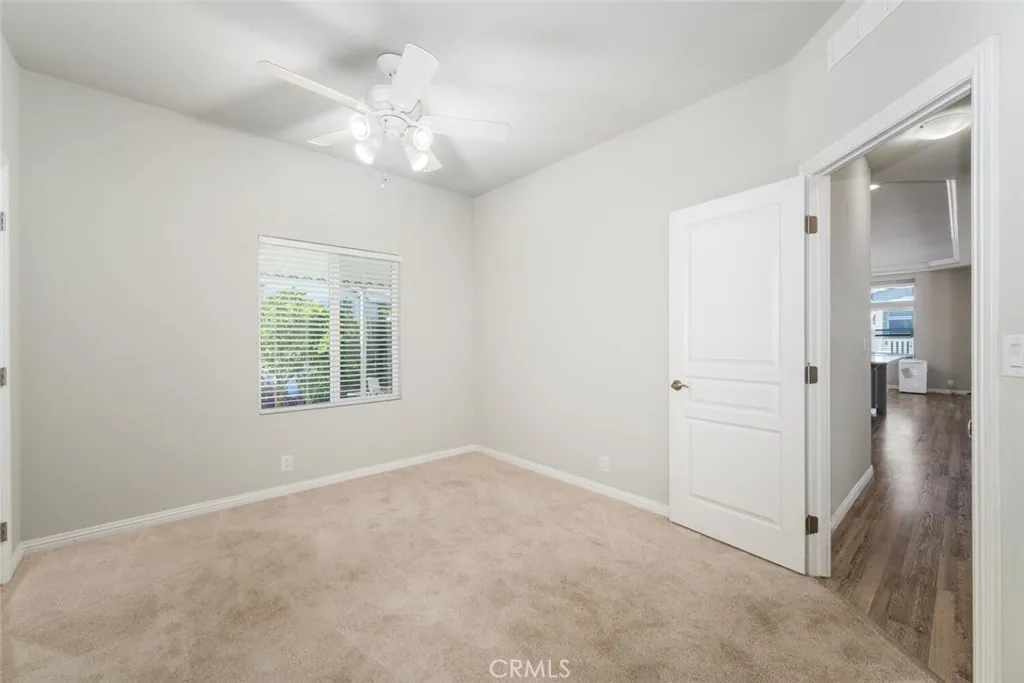 16222 Monterey Lane, Unit 285 Huntington Beach, CA 92649 - Photo 35 of 59 an empty room with chandelier fan and windows