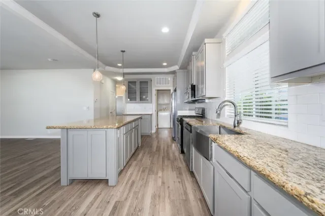 a kitchen with stainless steel appliances granite countertop a stove and a wooden cabinets
