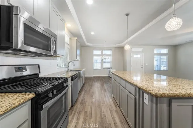 a kitchen with stainless steel appliances granite countertop a stove a sink and a microwave