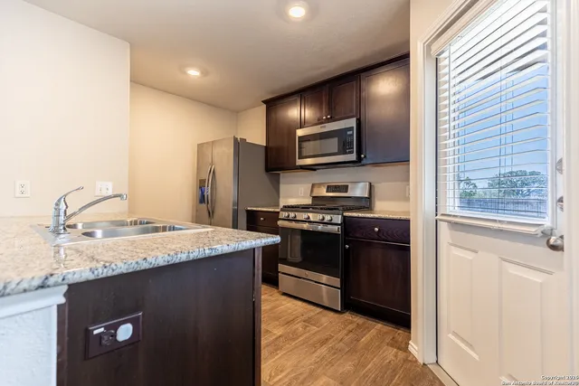 a kitchen with stainless steel appliances granite countertop a refrigerator and a stove