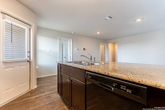 a kitchen with stainless steel appliances granite countertop a sink stove and cabinets