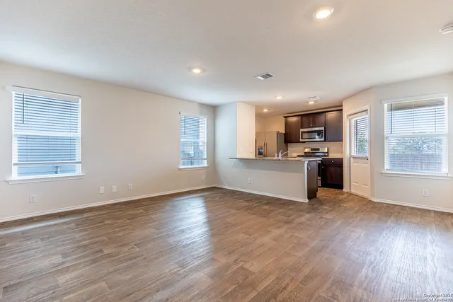 a view of a kitchen with a sink stove cabinets and empty room
