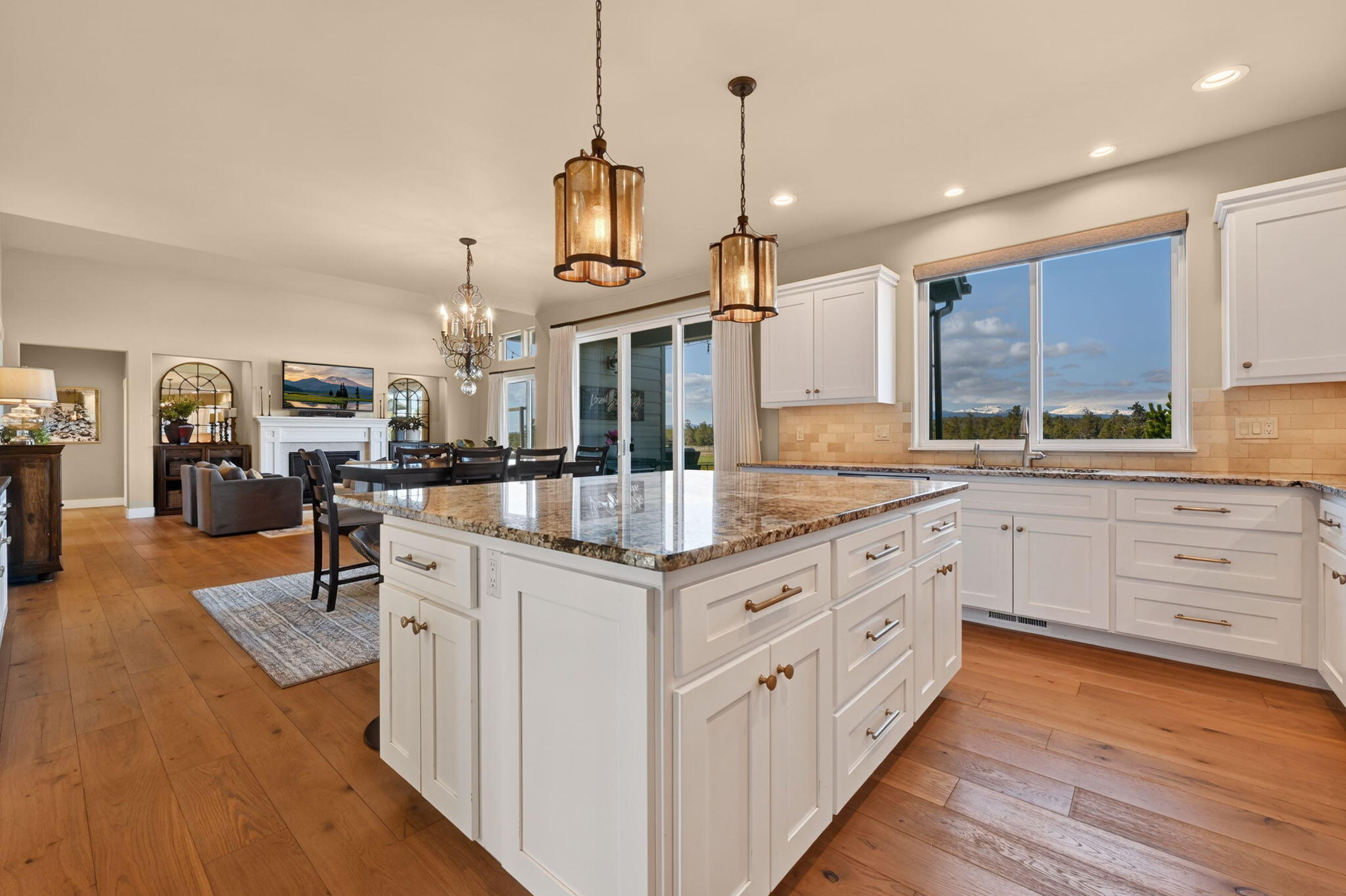 66355 Barr Road Bend, OR 97703 - Photo 16 of 56 a kitchen with stainless steel appliances kitchen island granite countertop a table chairs and a wooden floor