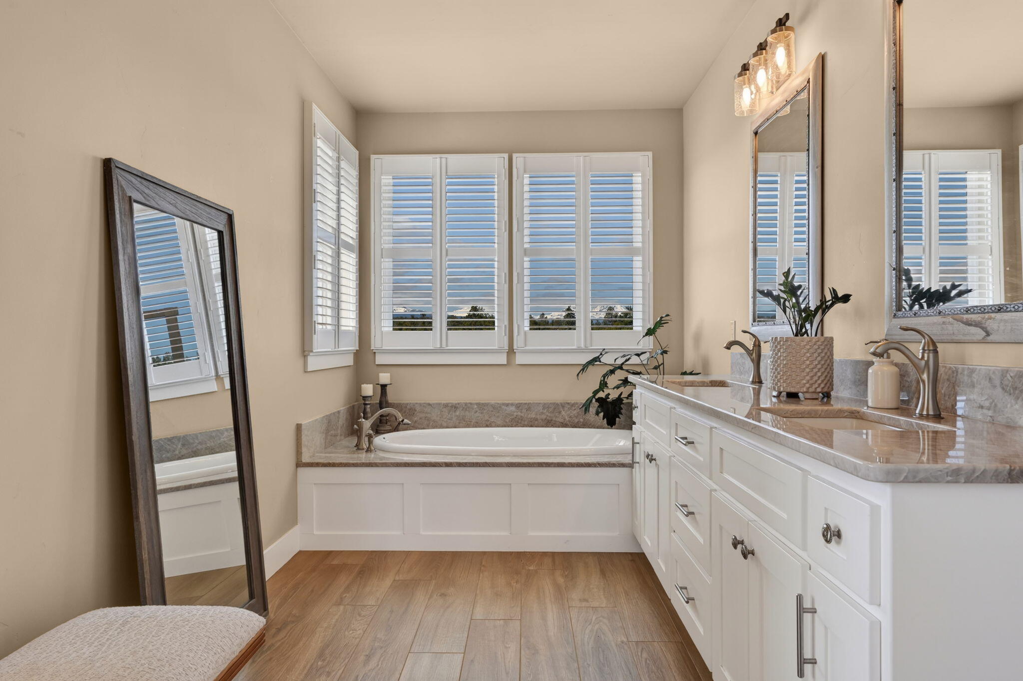 66355 Barr Road Bend, OR 97703 - Photo 23 of 56 a bathroom with a tub a sink and a large mirror next to a window