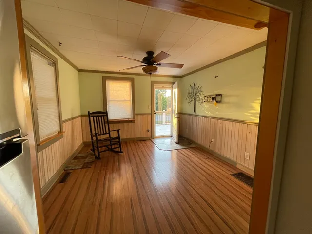 a view of a hallway with wooden floor and furniture