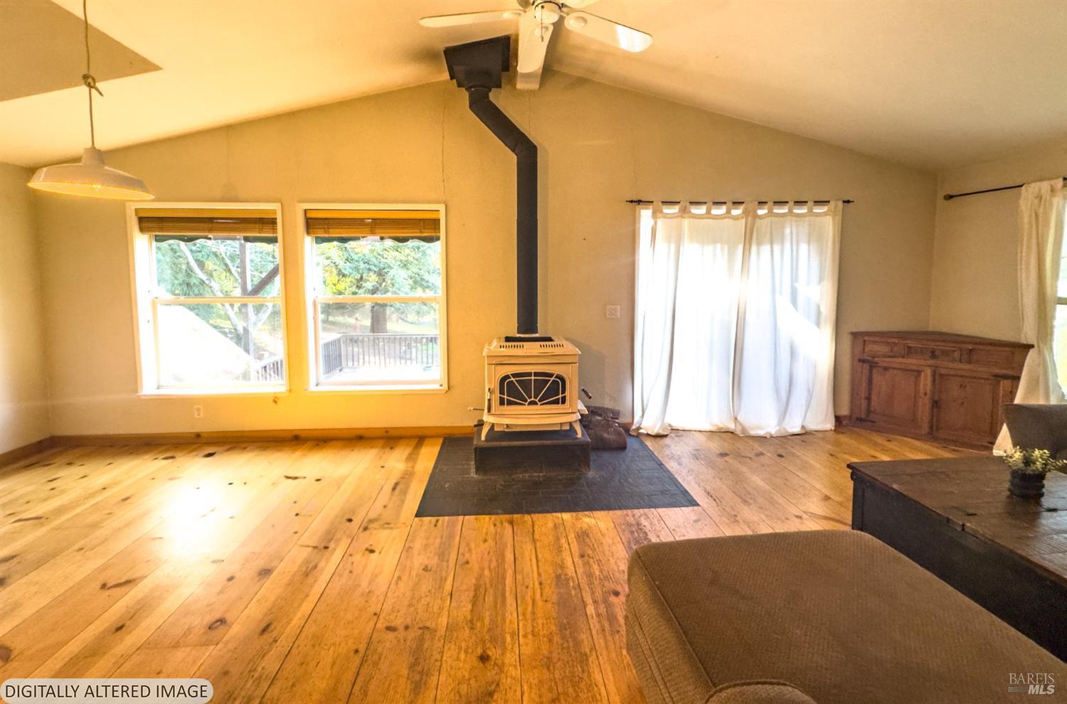 14475 Poonkinney Road Dos Rios, CA 95429 - Photo 6 of 25 a spacious bedroom with a bed and wooden floor