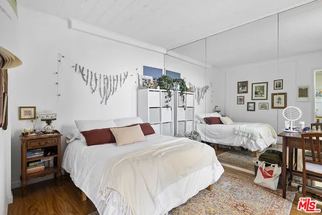 a bedroom with bed and wooden floor