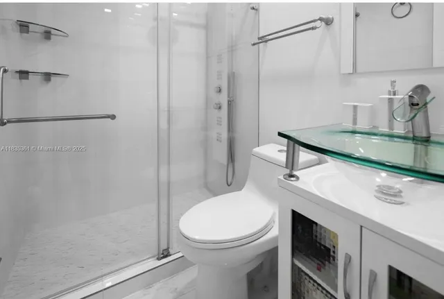 a bathroom with a sink a toilet and shower
