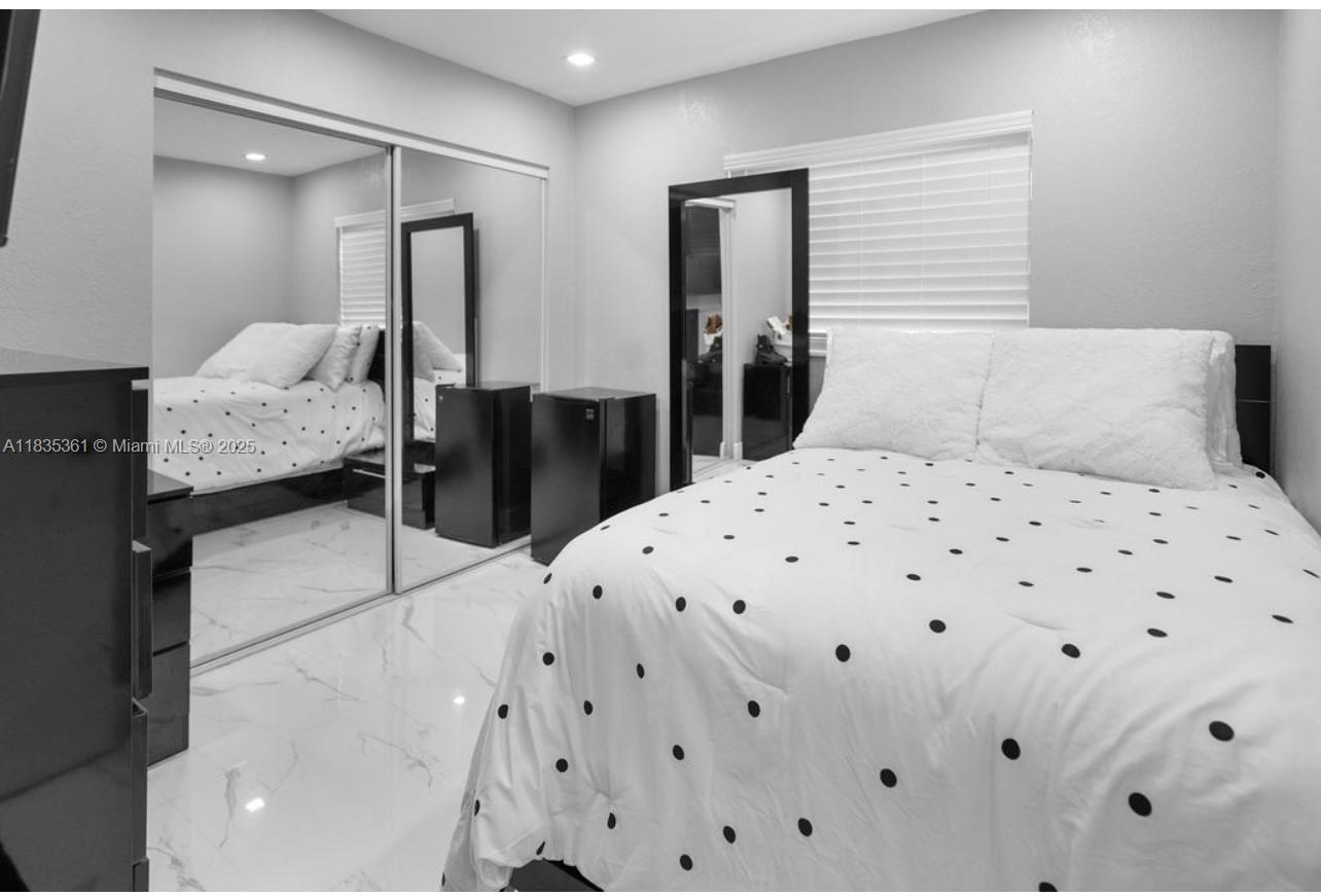 1158 West 41st Street, Unit 87 Hialeah, FL 33012 - Photo 13 of 16 a bedroom with a bed and a large mirror