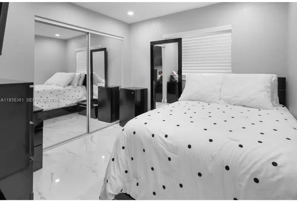 a bedroom with a bed and a large mirror