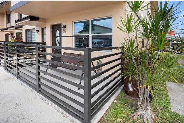 a view of a house with a yard and wooden fence