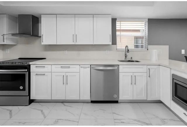 a kitchen with white cabinets and appliances