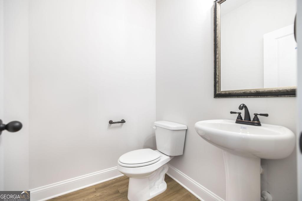 409 Bella Notte Circle, Unit 1D Warner Robins, GA 31088 - Photo 14 of 34 a bathroom with a toilet sink and mirror