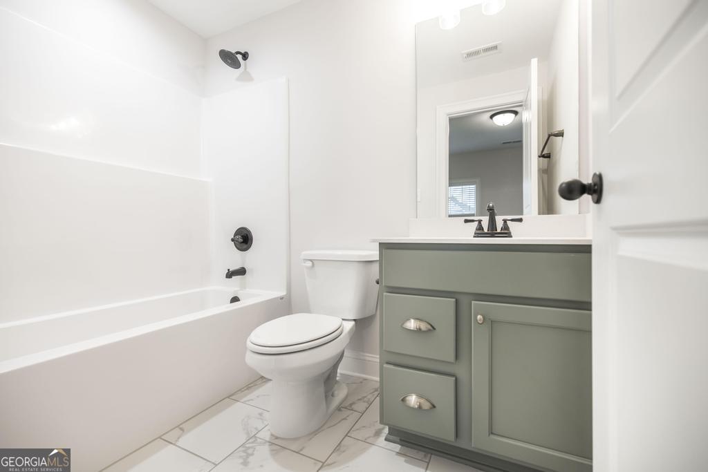 409 Bella Notte Circle, Unit 1D Warner Robins, GA 31088 - Photo 17 of 34 a bathroom with a sink toilet and shower