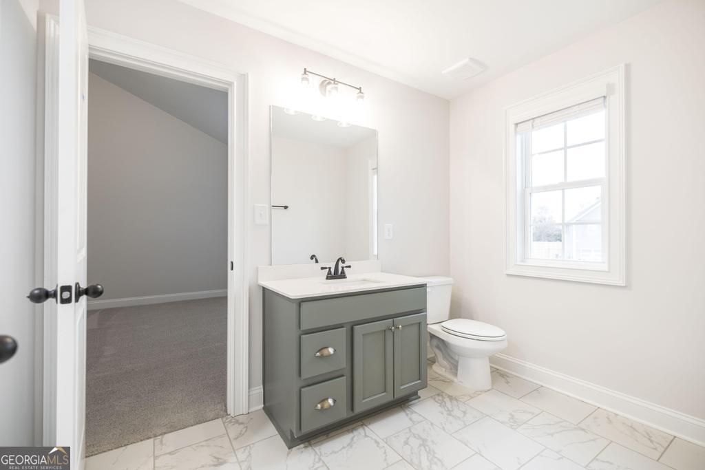 409 Bella Notte Circle, Unit 1D Warner Robins, GA 31088 - Photo 21 of 34 a bathroom with a toilet sink and mirror