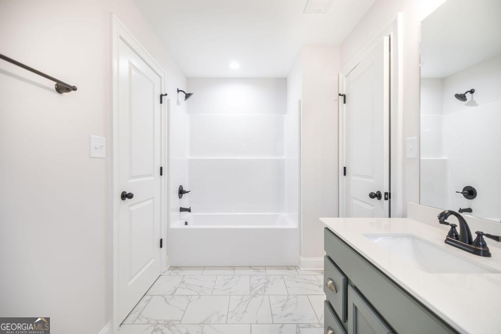 409 Bella Notte Circle, Unit 1D Warner Robins, GA 31088 - Photo 22 of 34 a bathroom with a sink a toilet and shower