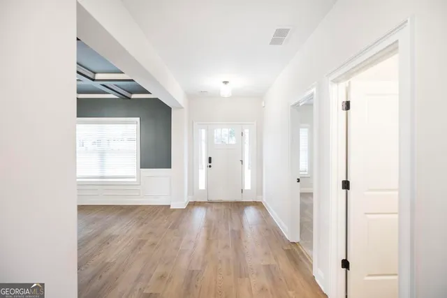 an empty room with wooden floor and windows