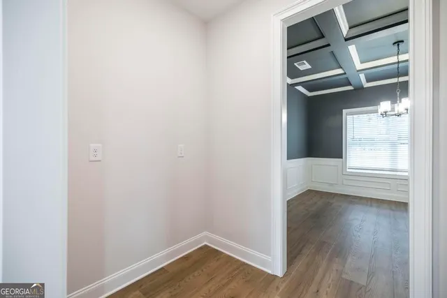 an empty room with wooden floor fireplace and windows
