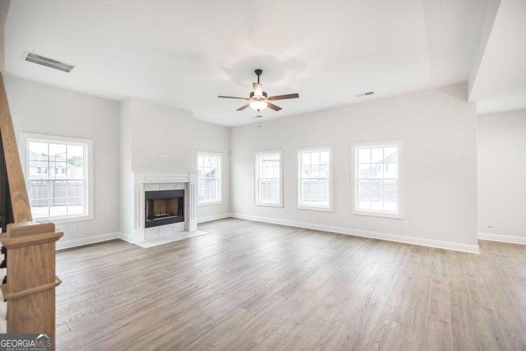 409 Bella Notte Circle, Unit 1D Warner Robins, GA 31088 - Photo 6 of 34 an empty room with wooden floor fireplace and windows