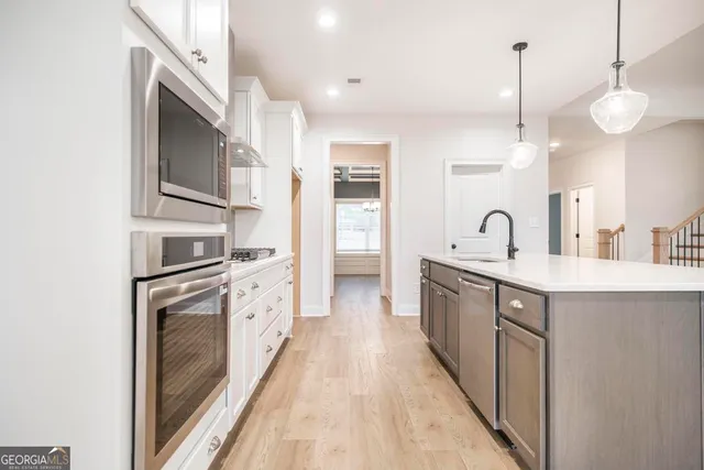 a view of kitchen with kitchen island a island a sink a stove and a window