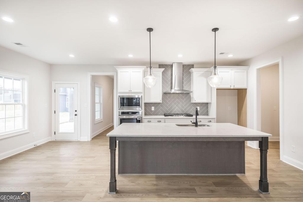 409 Bella Notte Circle, Unit 1D Warner Robins, GA 31088 - Photo 9 of 34 a view of kitchen with kitchen island a island a sink a stove and a window