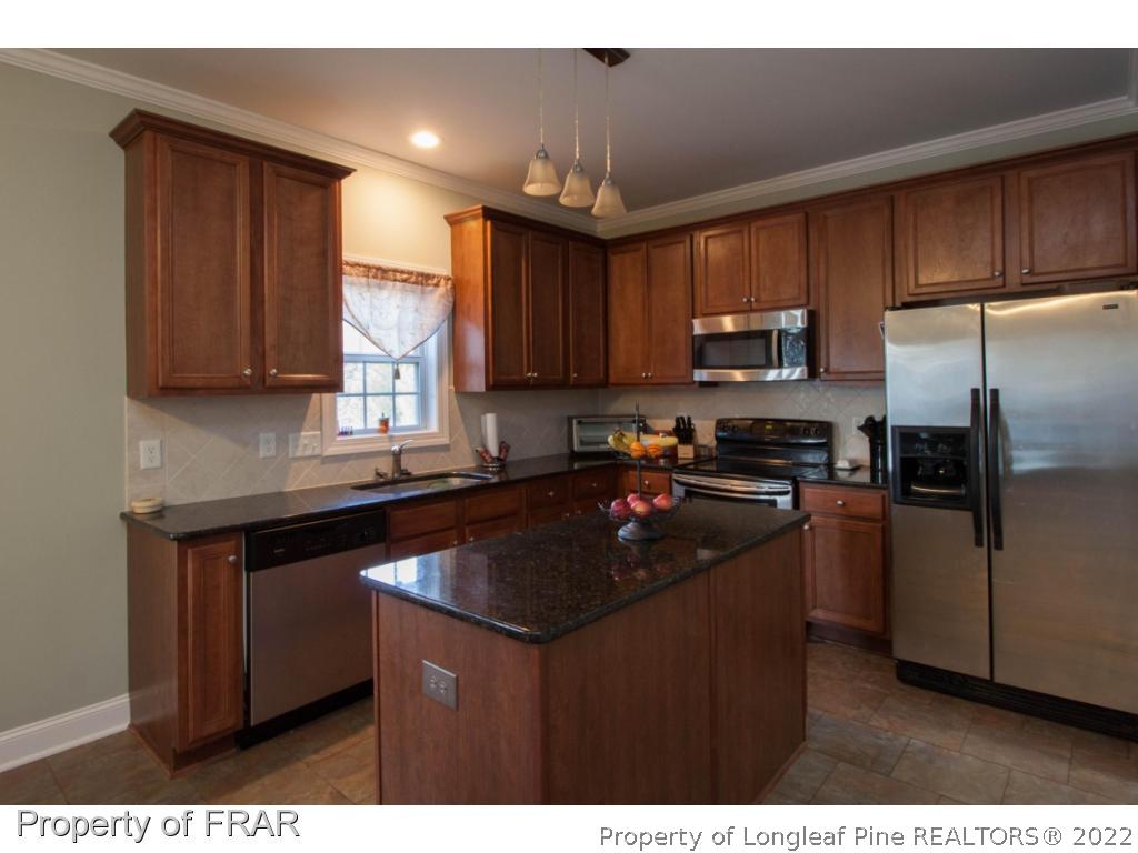510 Booth Pond Road Raeford, NC 28376 - Photo 18 of 36 a kitchen with a refrigerator sink and cabinets