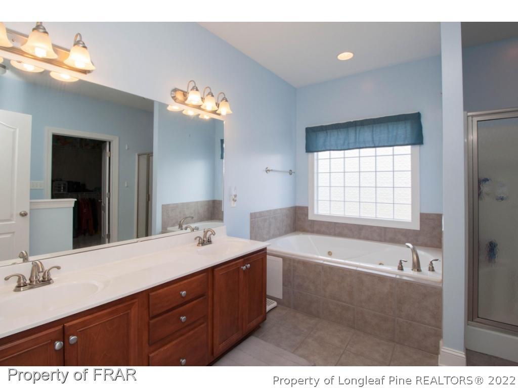 510 Booth Pond Road Raeford, NC 28376 - Photo 24 of 36 a bathroom with a tub double sink mirror and