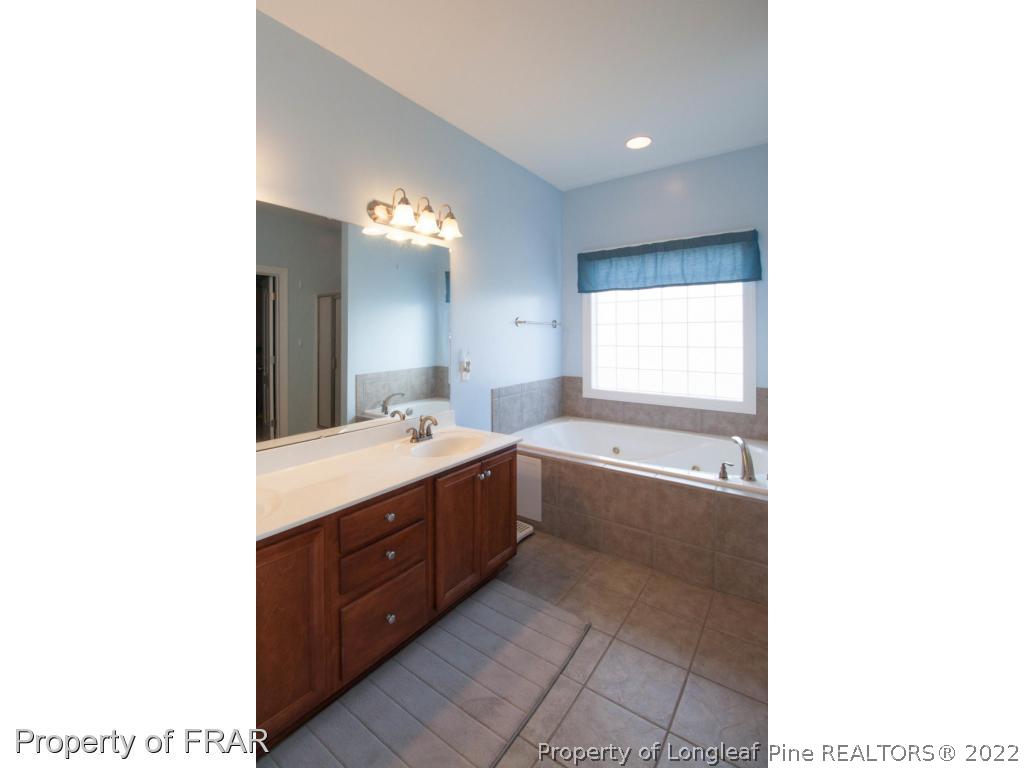 510 Booth Pond Road Raeford, NC 28376 - Photo 25 of 36 a bathroom with a tub sink and mirror