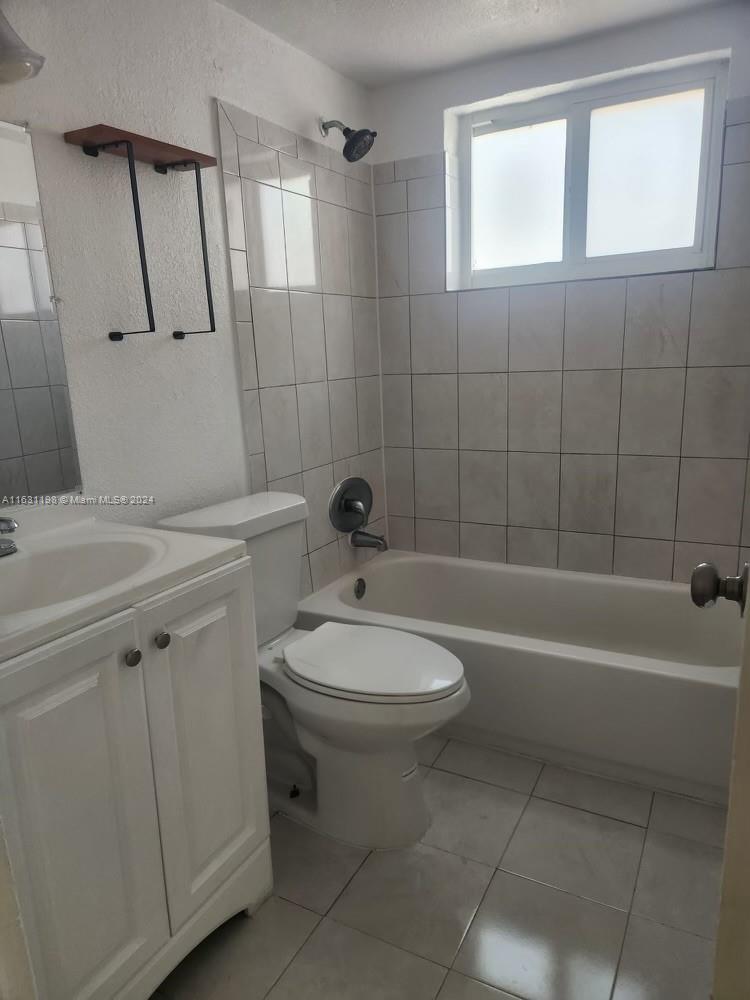 10 Northwest 48th Place, Unit 1 Miami, FL 33126 - Photo 3 of 10 a bathroom with a toilet a sink a mirror and bathtub