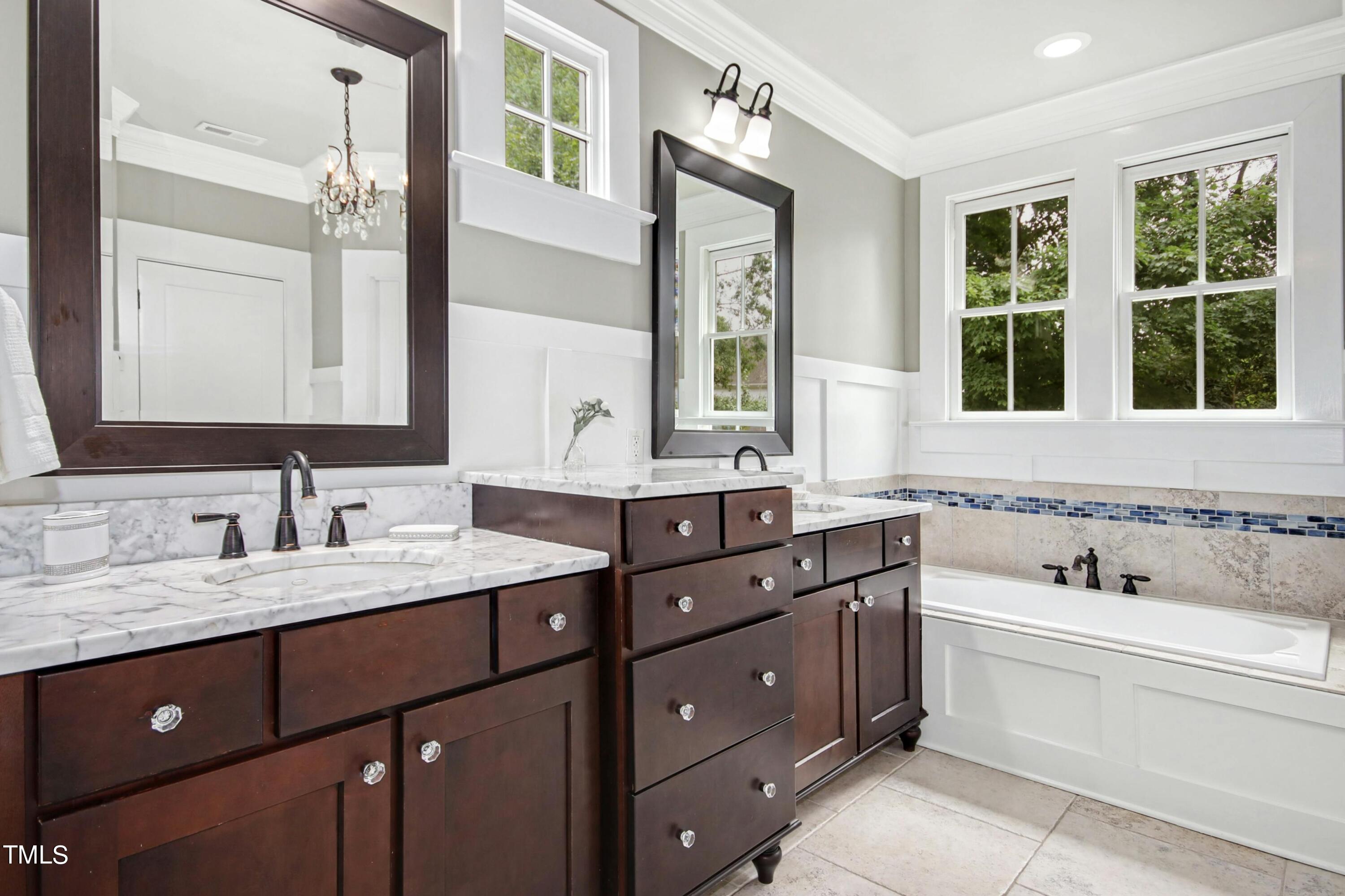 512 Peebles Street Raleigh, NC 27608 - Photo 28 of 45 a bathroom with a tub double sink window and mirror