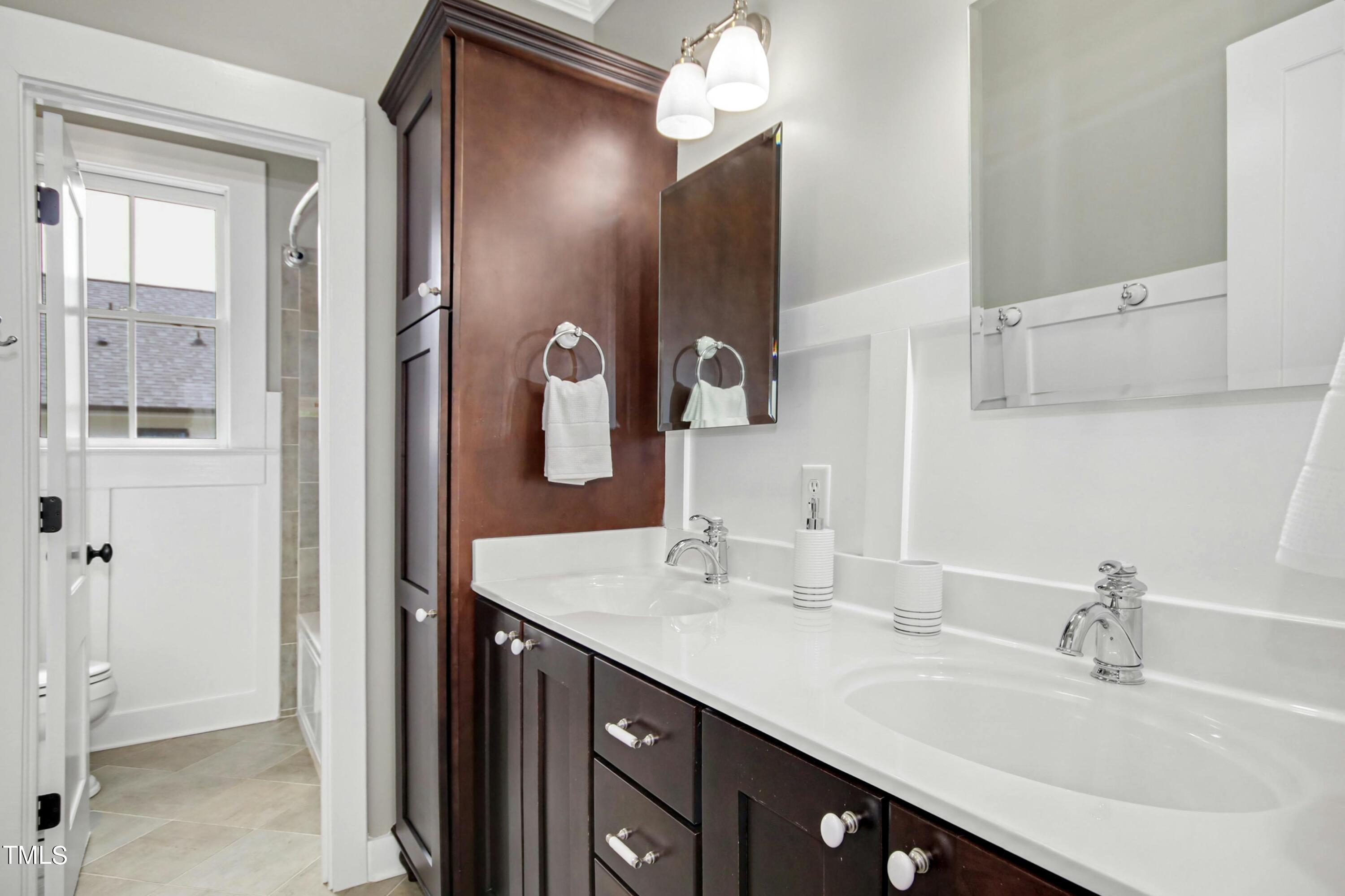 512 Peebles Street Raleigh, NC 27608 - Photo 35 of 45 a bathroom with a double vanity sink and a mirror
