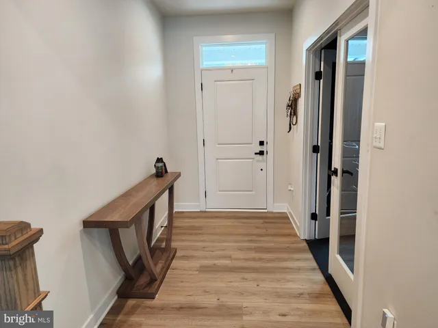 a view of a hallway with wooden floor and staircase