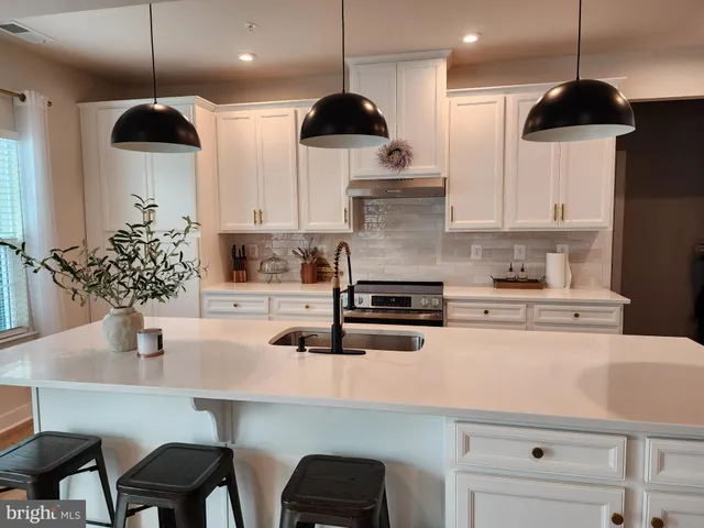 a kitchen with stainless steel appliances a dining table chairs and a view of living room