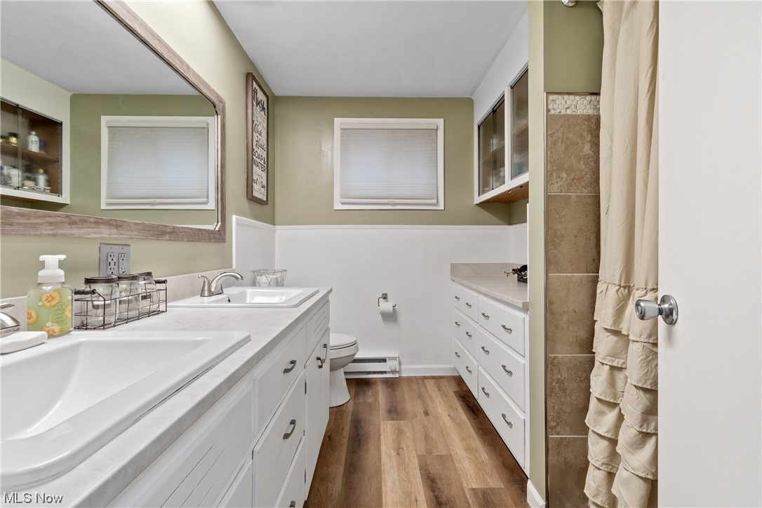 5369 Ridge Avenue Southeast Canton, OH 44707 - Photo 21 of 33 Bathroom featuring double vanity, wood-type flooring, toilet, and a baseboard radiator