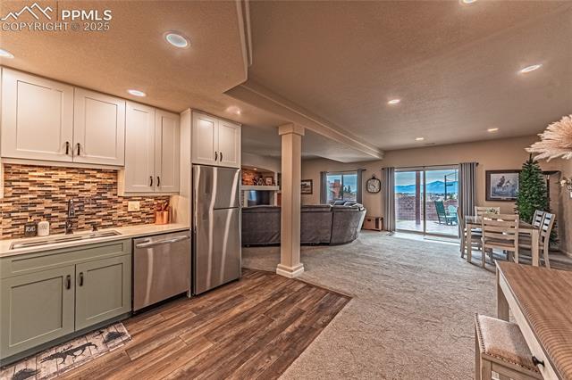 13812 Windy Oaks Road Colorado Springs, CO 80921 - Photo 41 of 50 Kitchen with light countertops, decorative columns, decorative backsplash, a sink, and appliances with stainless steel finishes