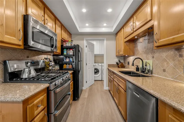 a kitchen with stainless steel appliances granite countertop a sink stove and refrigerator
