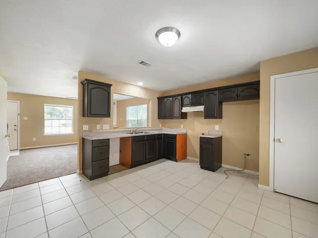 a large kitchen with a stove a sink dishwasher and a refrigerator