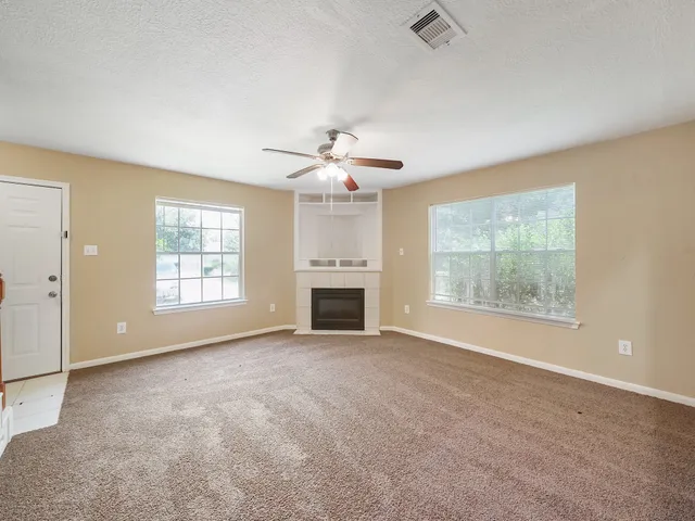 an empty room with windows and a fireplace