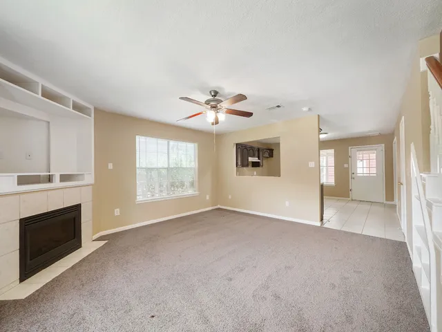 a view of an empty room with a fireplace and a window