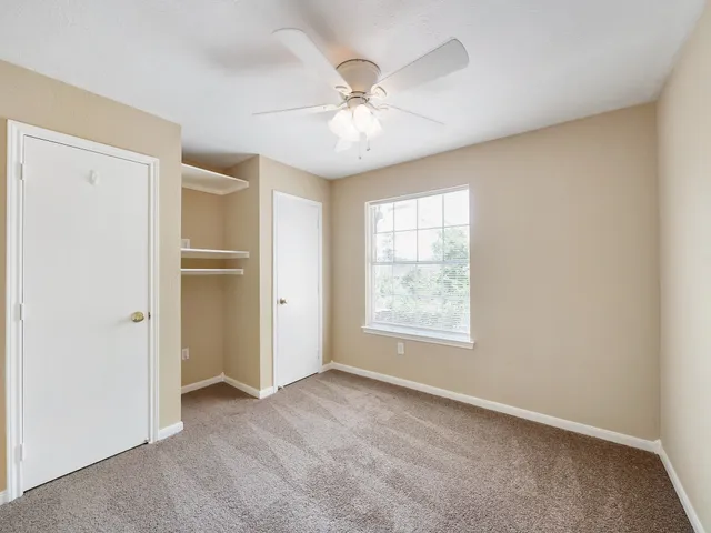 an empty room with fan and windows