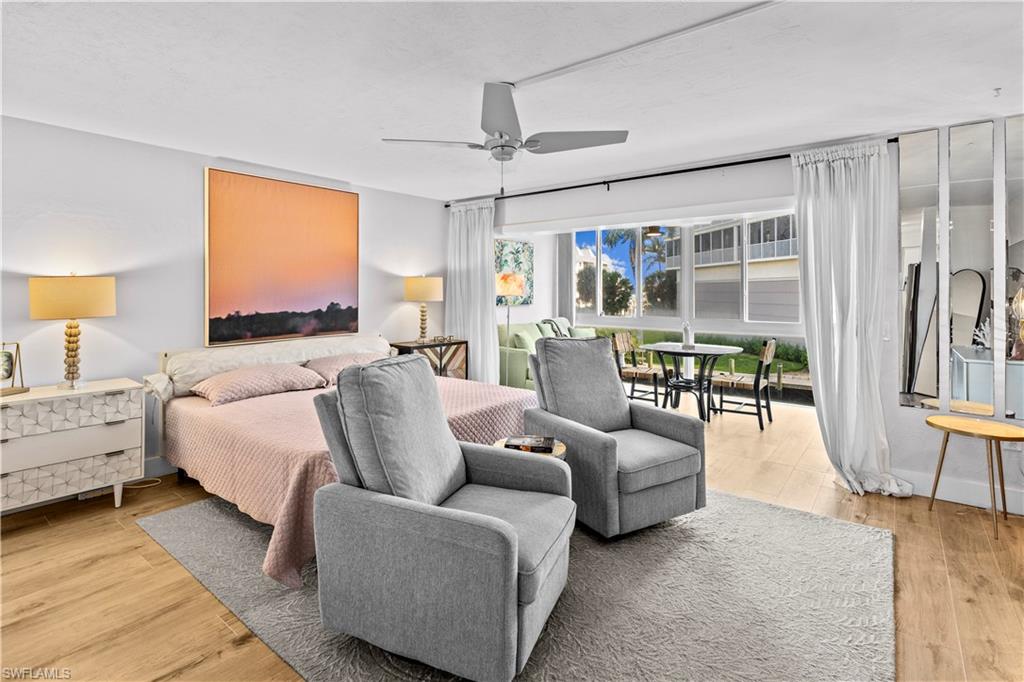377 Vanderbilt Beach Road, Unit 102 Naples, FL 34108 - Photo 9 of 19 a living room with furniture and a large window