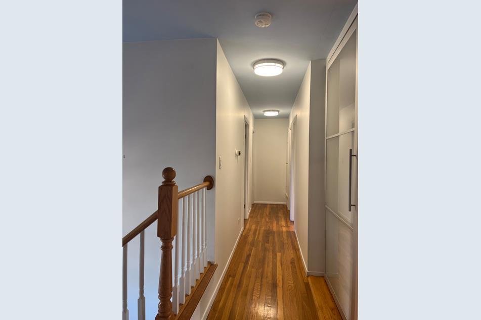 1345 Hassell Drive Hoffman Estates, IL 60169 - Photo 13 of 36 a view of a hallway with a white walls and wooden floor