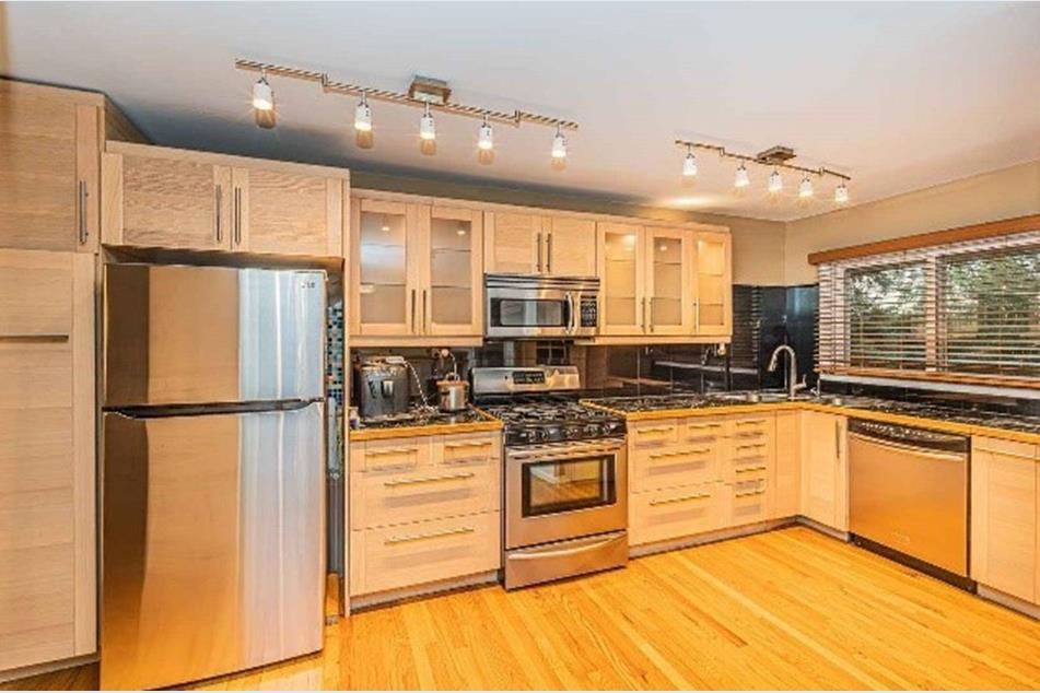 1345 Hassell Drive Hoffman Estates, IL 60169 - Photo 3 of 36 a kitchen with stainless steel appliances granite countertop a refrigerator a stove and a sink